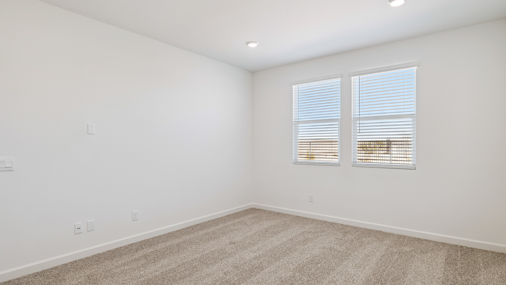 A spacious primary bedroom emphasizing open space and natural lighting.