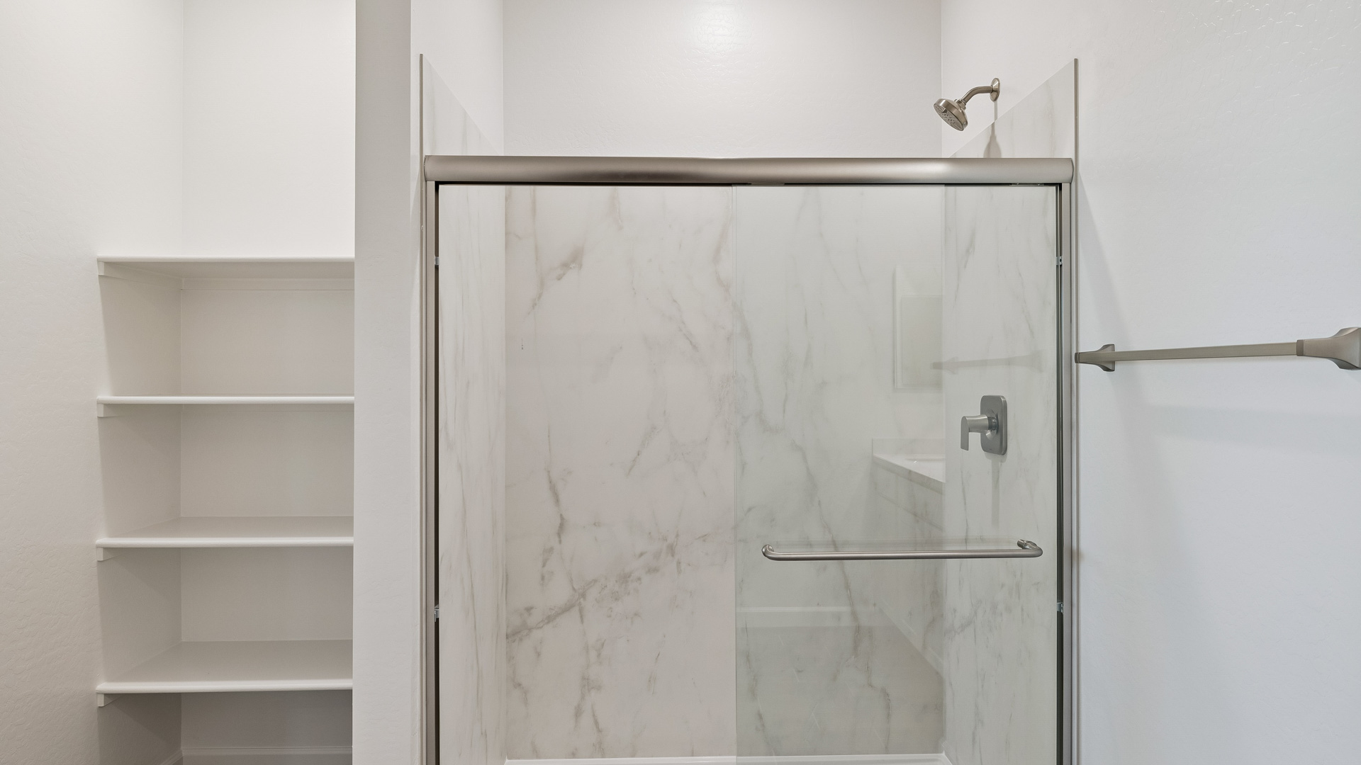 Modern primary bathroom with double vanities, quartz countertops with a walk-in shower and a walk-in closet.