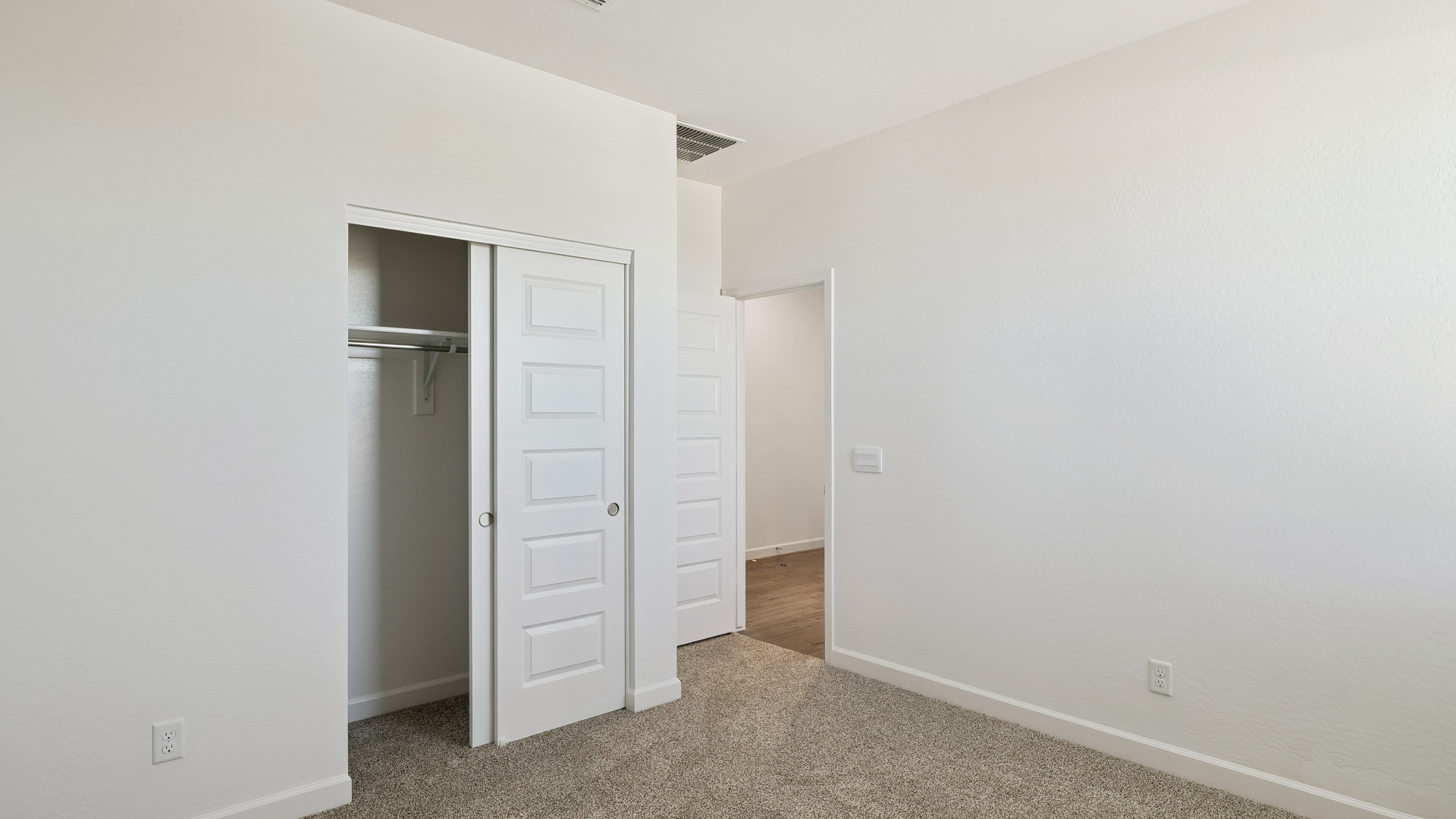 Comfortable guest bedroom featuring neutral-toned walls and a large closet.