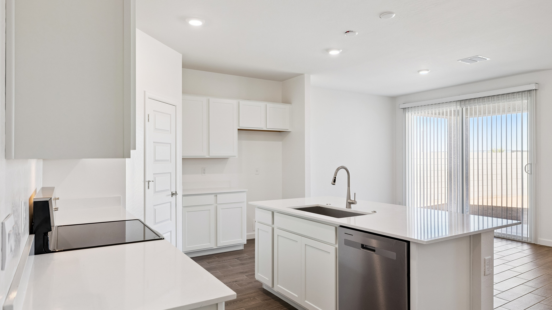 Bright and spacious kitchen with quartz countertops, stainless steel appliances, and an island with bar seating.