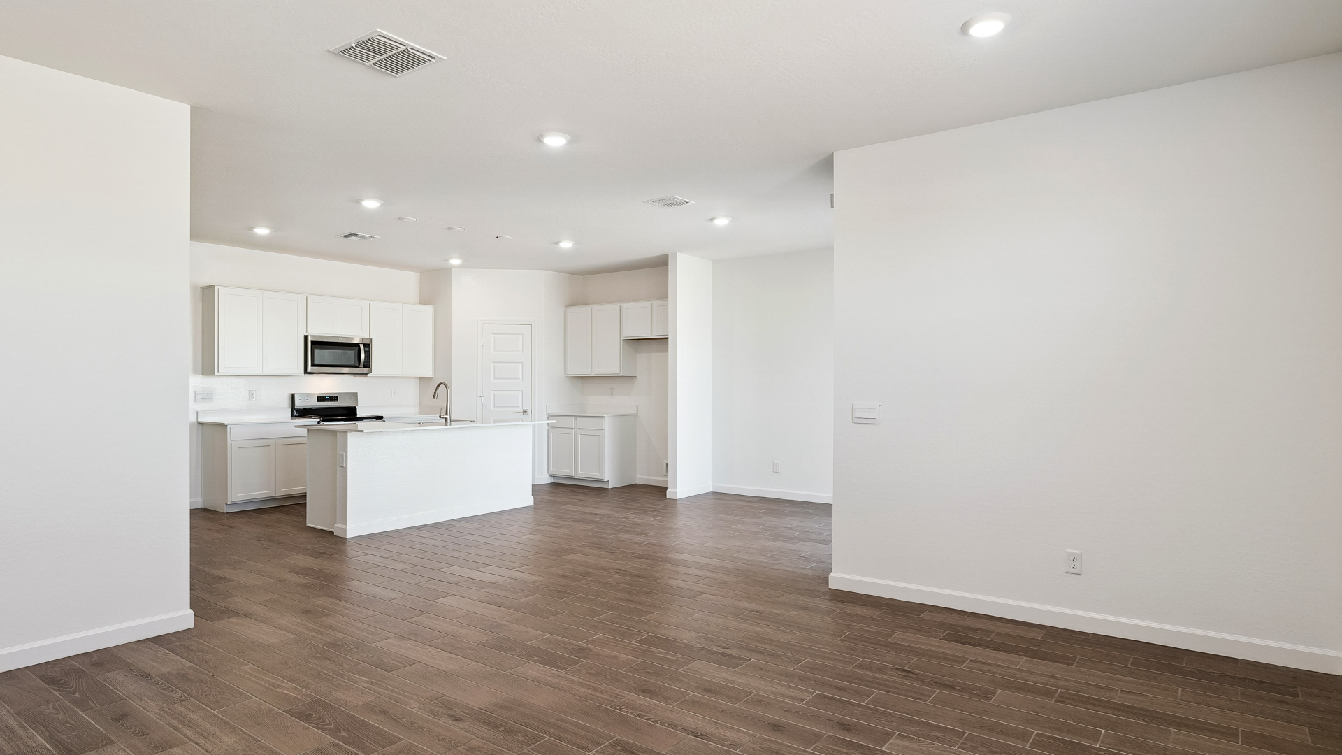 A well-organized living room that includes a kitchen and dining area, creating a warm and welcoming environment for gatherings.