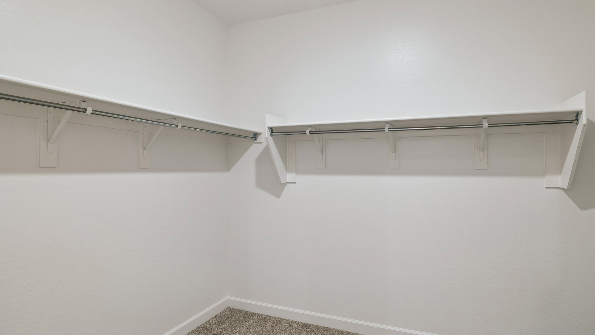 Modern primary bathroom with double vanities, quartz countertops with a walk-in shower and a walk-in closet.