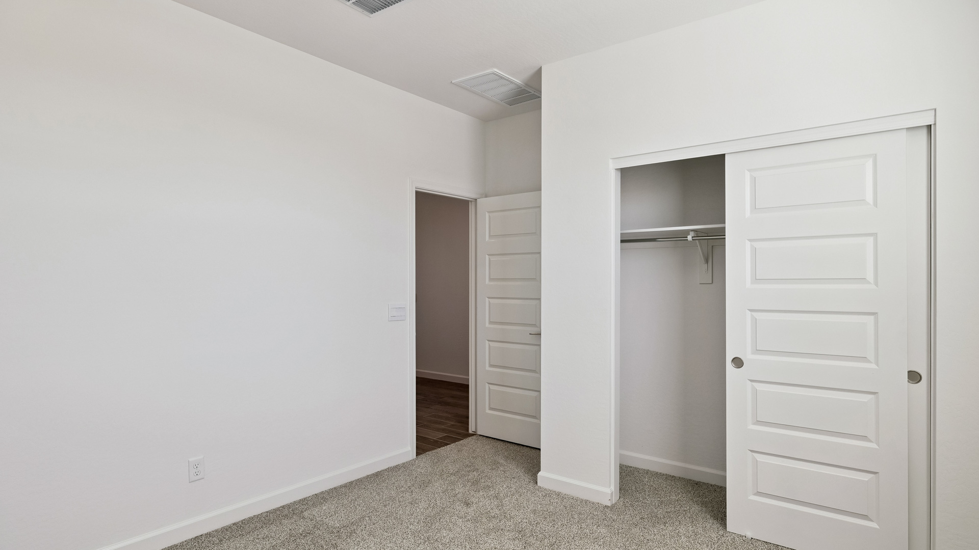 Comfortable guest bedroom featuring neutral-toned walls and a large closet.