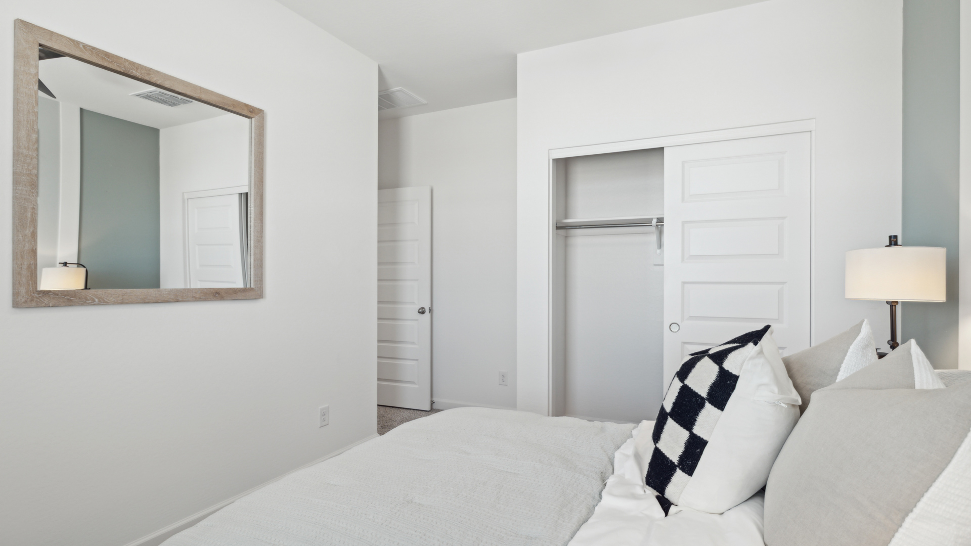Comfortable guest bedroom featuring neutral-toned walls and a large closet.