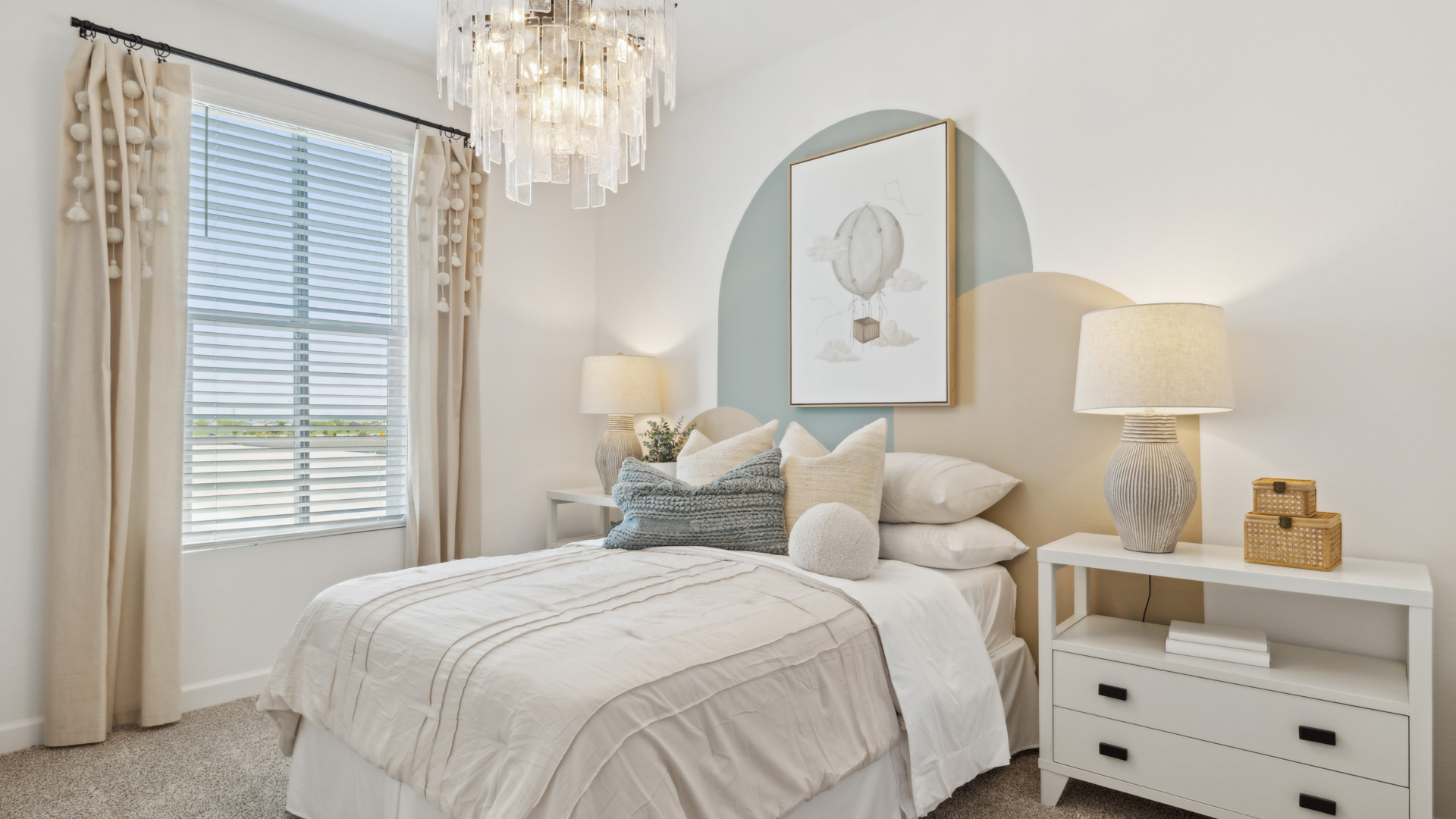 A vibrant kids' bedroom showcasing a neatly made bed, a stylish dresser, and a playful painting that adds charm.