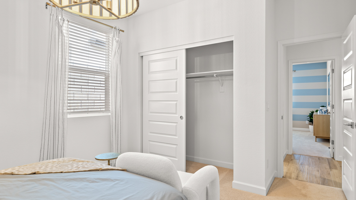 Comfortable guest bedroom featuring neutral-toned walls and a large closet.