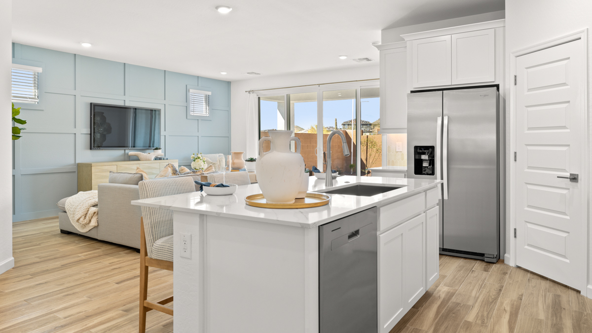 Bright and spacious kitchen with countertops, stainless steel appliances, and an island with bar seating.