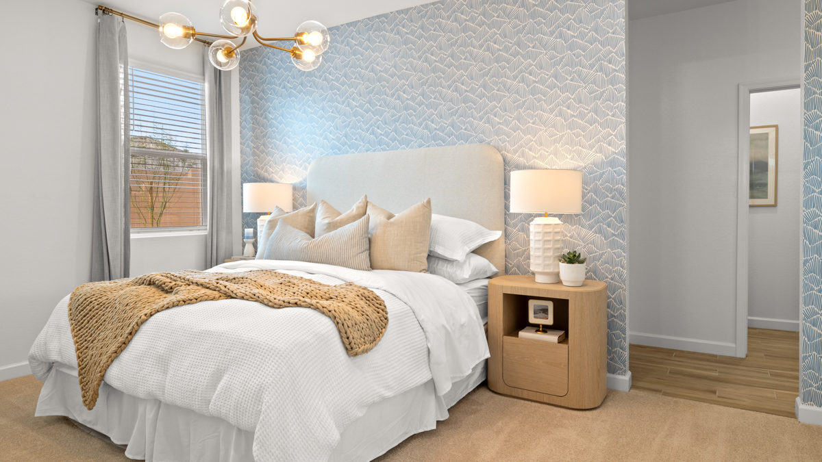 A spacious primary bedroom emphasizing open space and natural lighting.