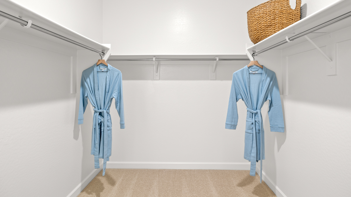 Modern primary bathroom with double vanities, countertops with a walk-in shower and a walk-in closet.