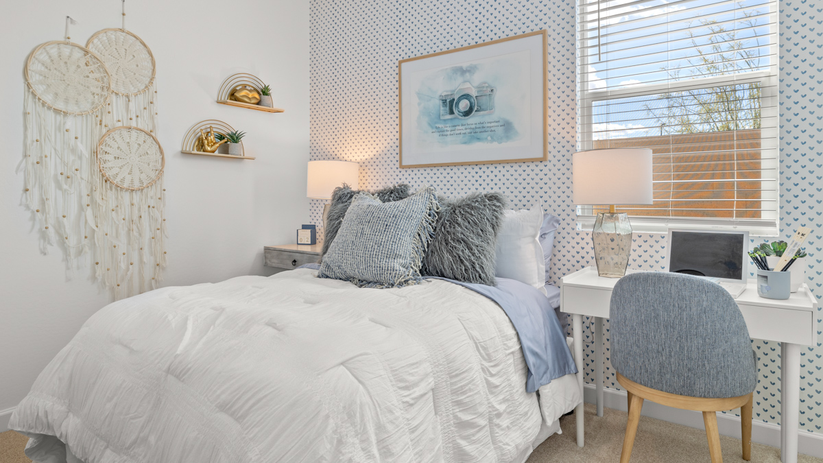 A vibrant kids' bedroom showcasing a neatly made bed, a stylish dresser, and a playful painting that adds charm.