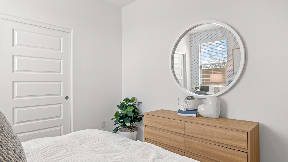 A vibrant kids' bedroom showcasing a neatly made bed, a stylish dresser, and a playful painting that adds charm.