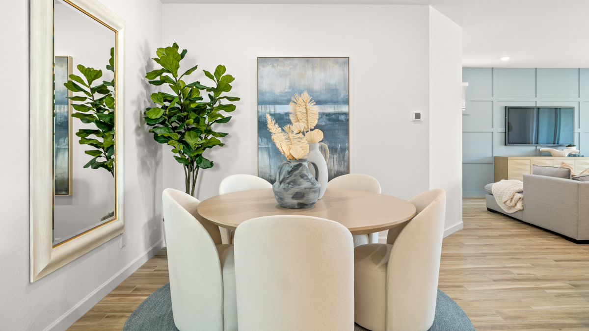 Formal dining room with large windows, vinyl wood floors, and view of the living room.