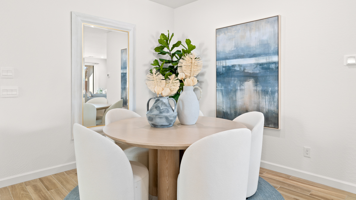 Formal dining room with large windows, vinyl wood floors, and view of the living room.