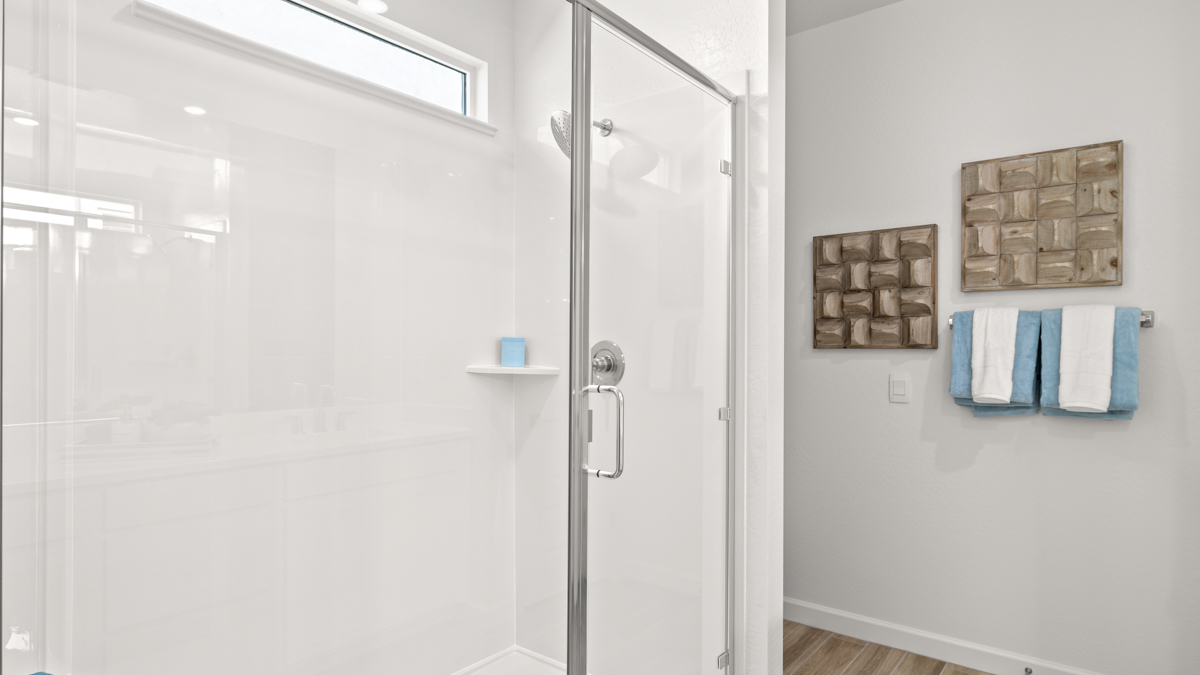 Modern primary bathroom with double vanities, countertops with a walk-in shower and a walk-in closet.