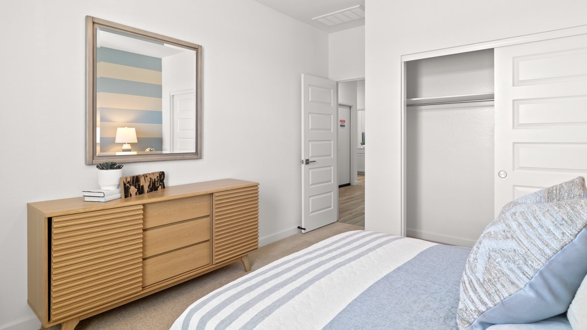 Comfortable guest bedroom featuring neutral-toned walls and a large closet.