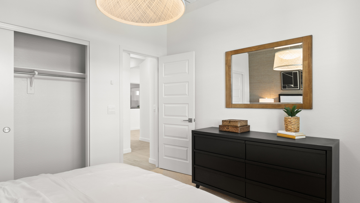 Comfortable guest bedroom featuring neutral-toned walls and a large closet.