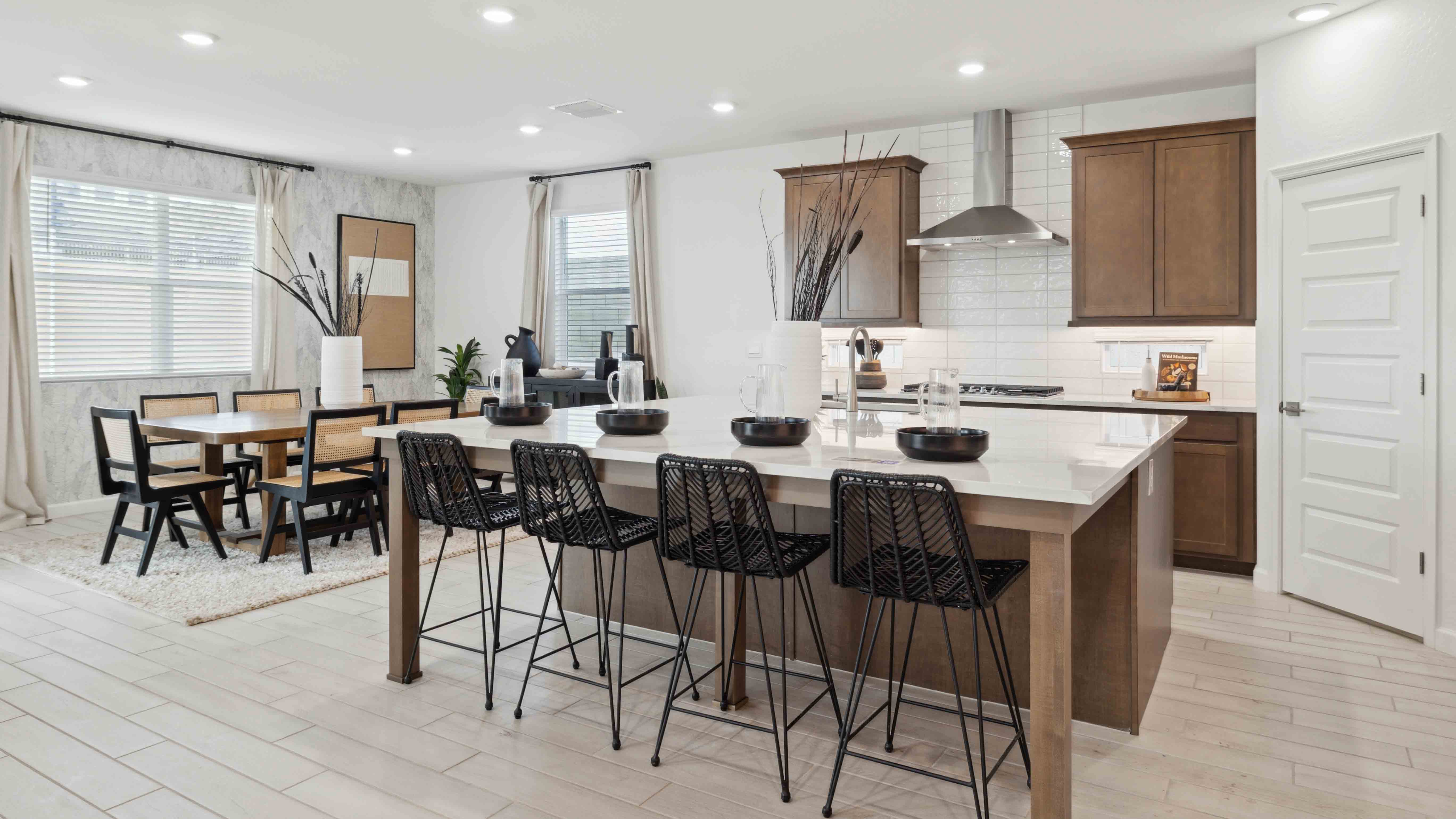 Bright and spacious kitchen with quartz countertops, stainless steel appliances, and an island with bar seating.