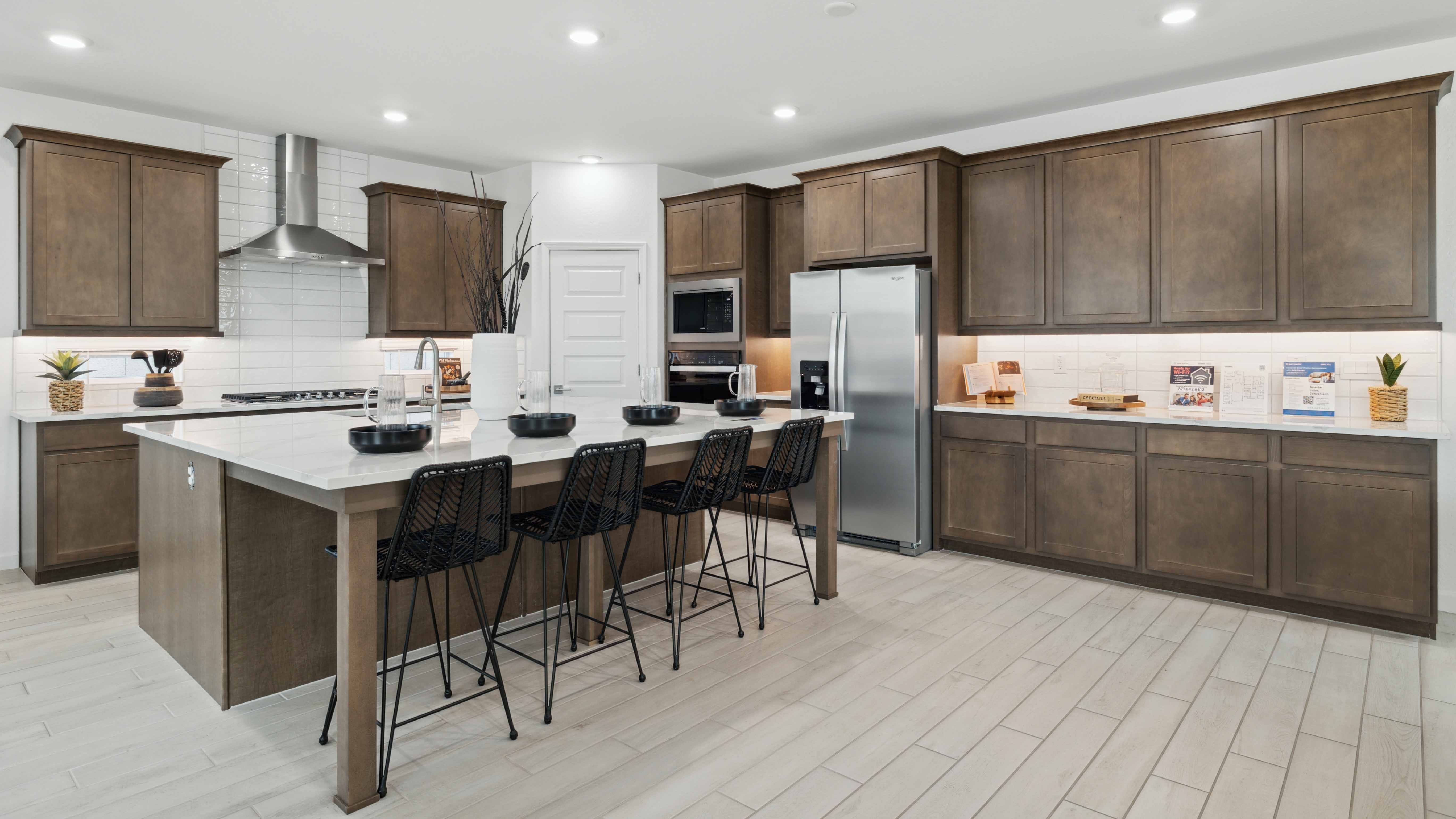 Bright and spacious kitchen with quartz countertops, stainless steel appliances, and an island with bar seating.