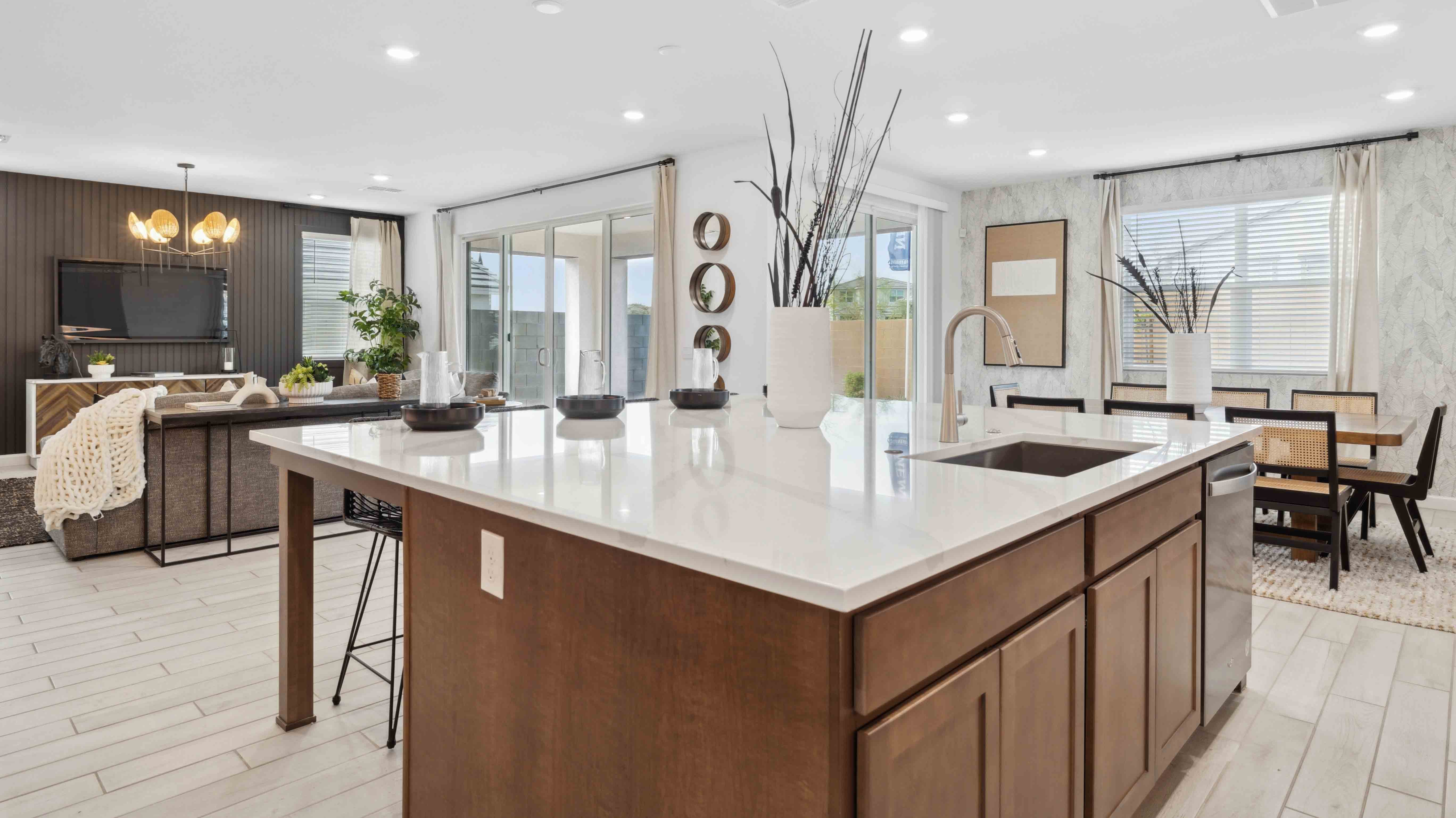 Bright and spacious kitchen with quartz countertops, stainless steel appliances, and an island with bar seating.
