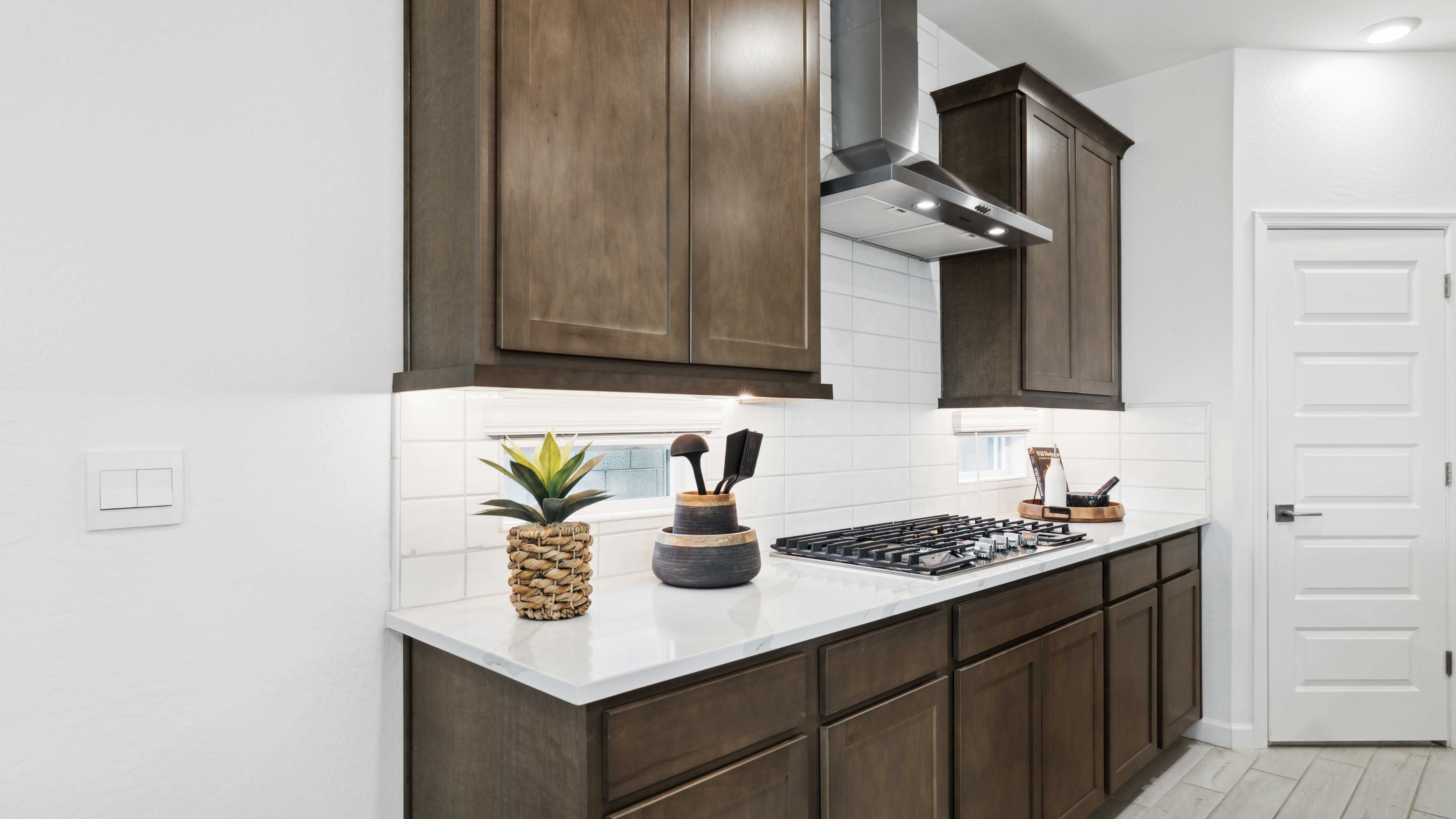 Bright and spacious kitchen with quartz countertops, stainless steel appliances, and an island with bar seating.