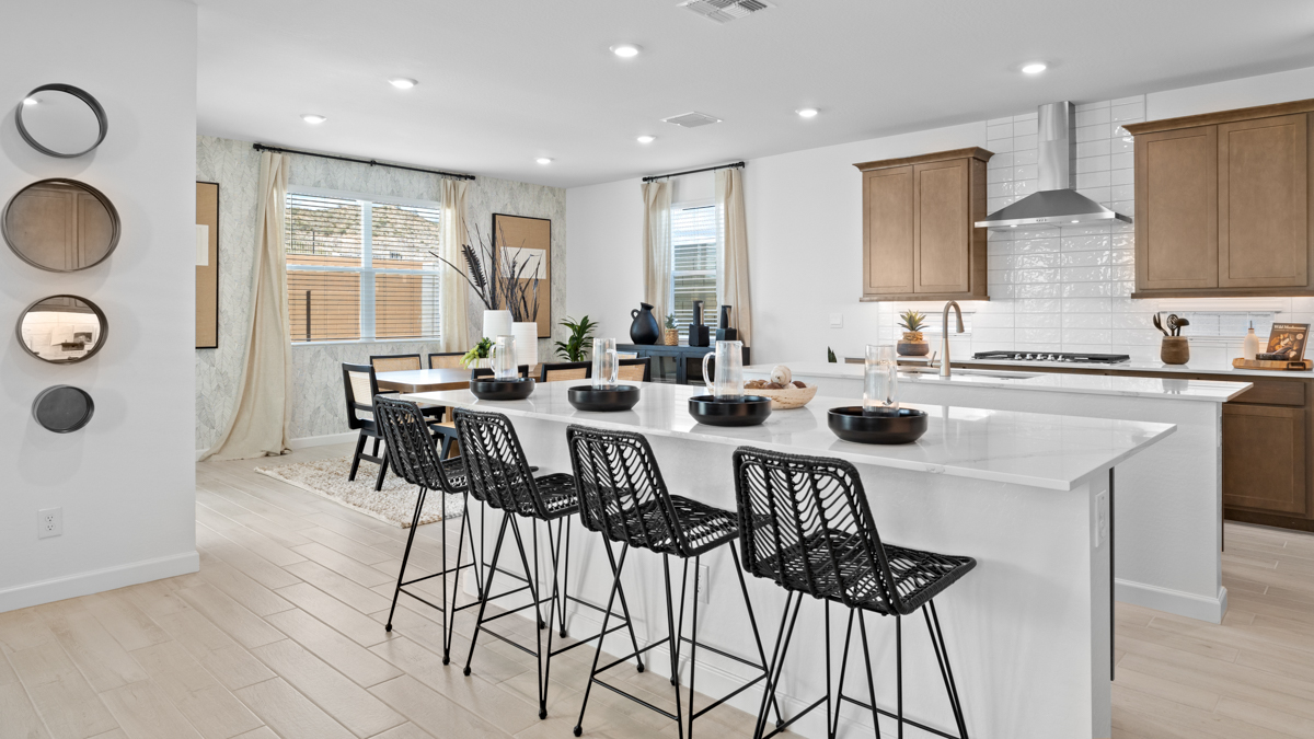 Bright and spacious kitchen with quartz countertops, stainless steel appliances, and an island with bar seating.