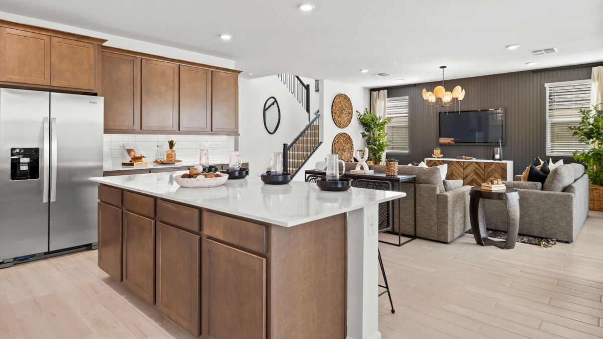 Bright and spacious kitchen with quartz countertops, stainless steel appliances, and an island with bar seating.