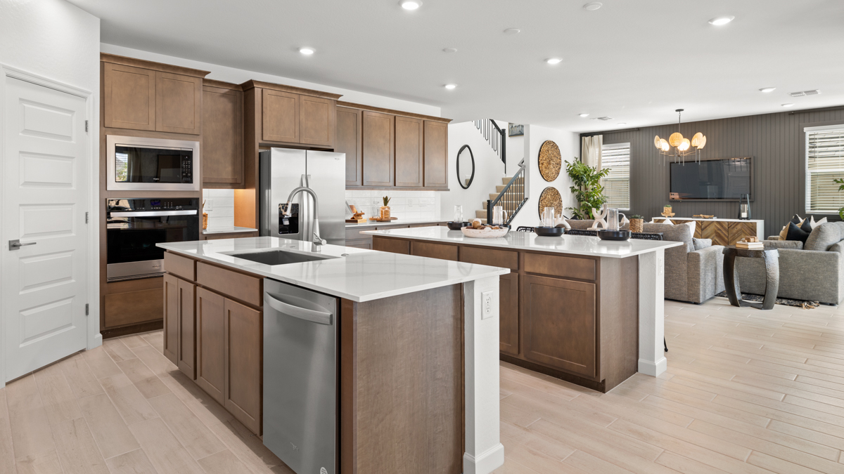 Bright and spacious kitchen with quartz countertops, stainless steel appliances, and an island with bar seating.