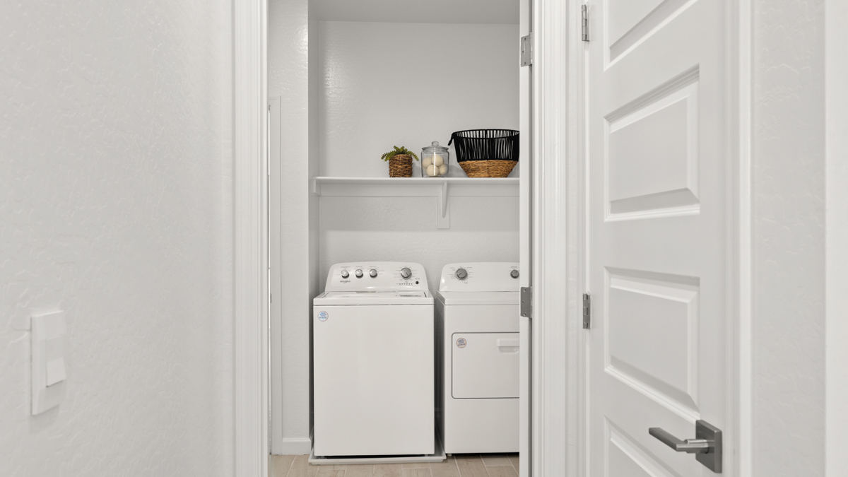 A laundry room featuring a washer and dryer, neatly arranged with ample space for laundry tasks and storage.
