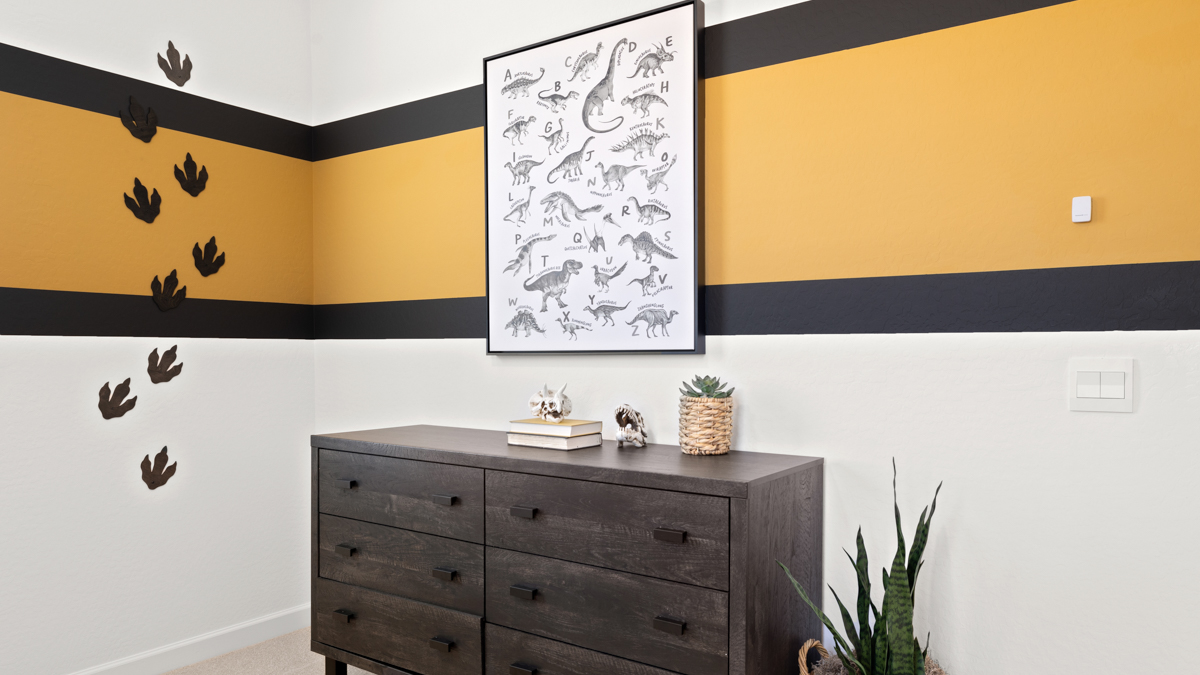 A vibrant kids' bedroom showcasing a neatly made bunkbed, a stylish dresser, and a playful painting that adds charm.