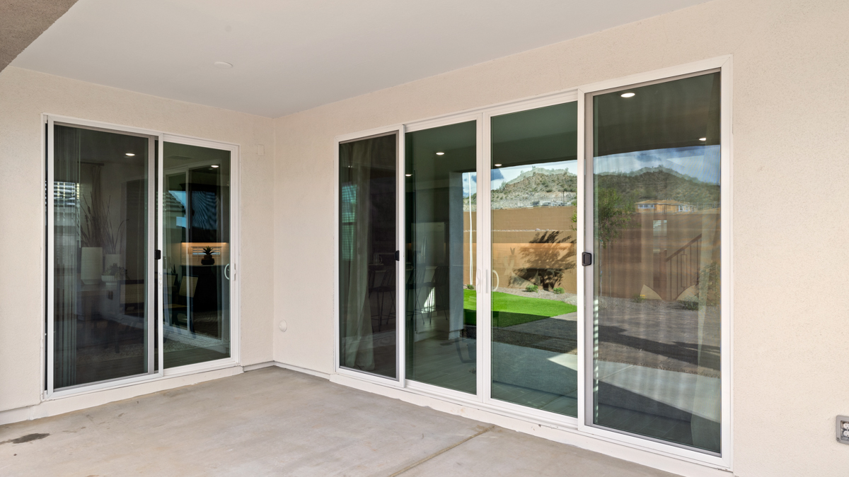 Outdoor covered patio with seating area overlooking a well-maintained lawn, perfect for relaxation.