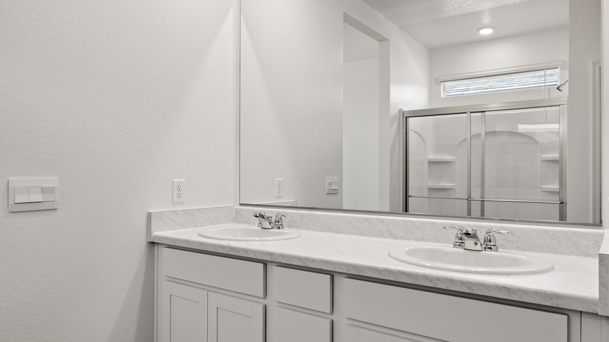 Primary bathroom with dual vanities.