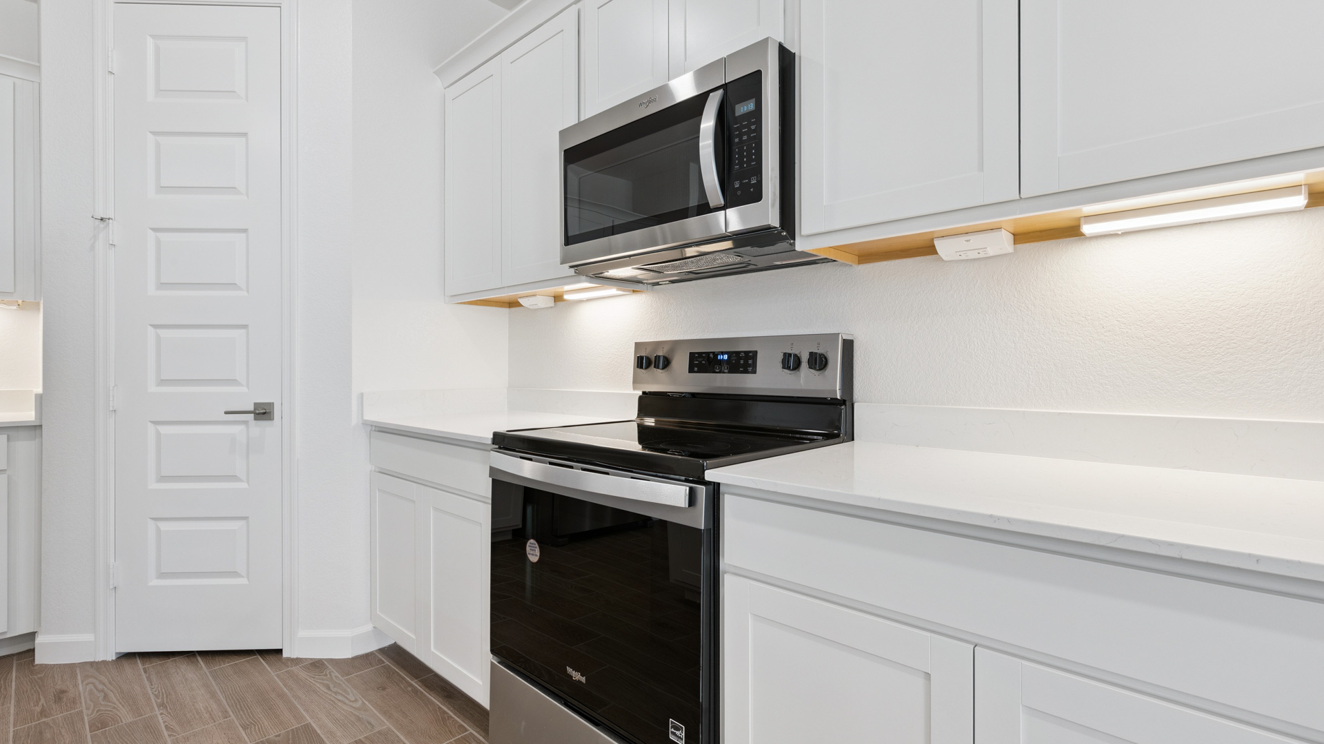 Bright and spacious kitchen with quartz countertops, stainless steel appliances, and an island with bar seating.
