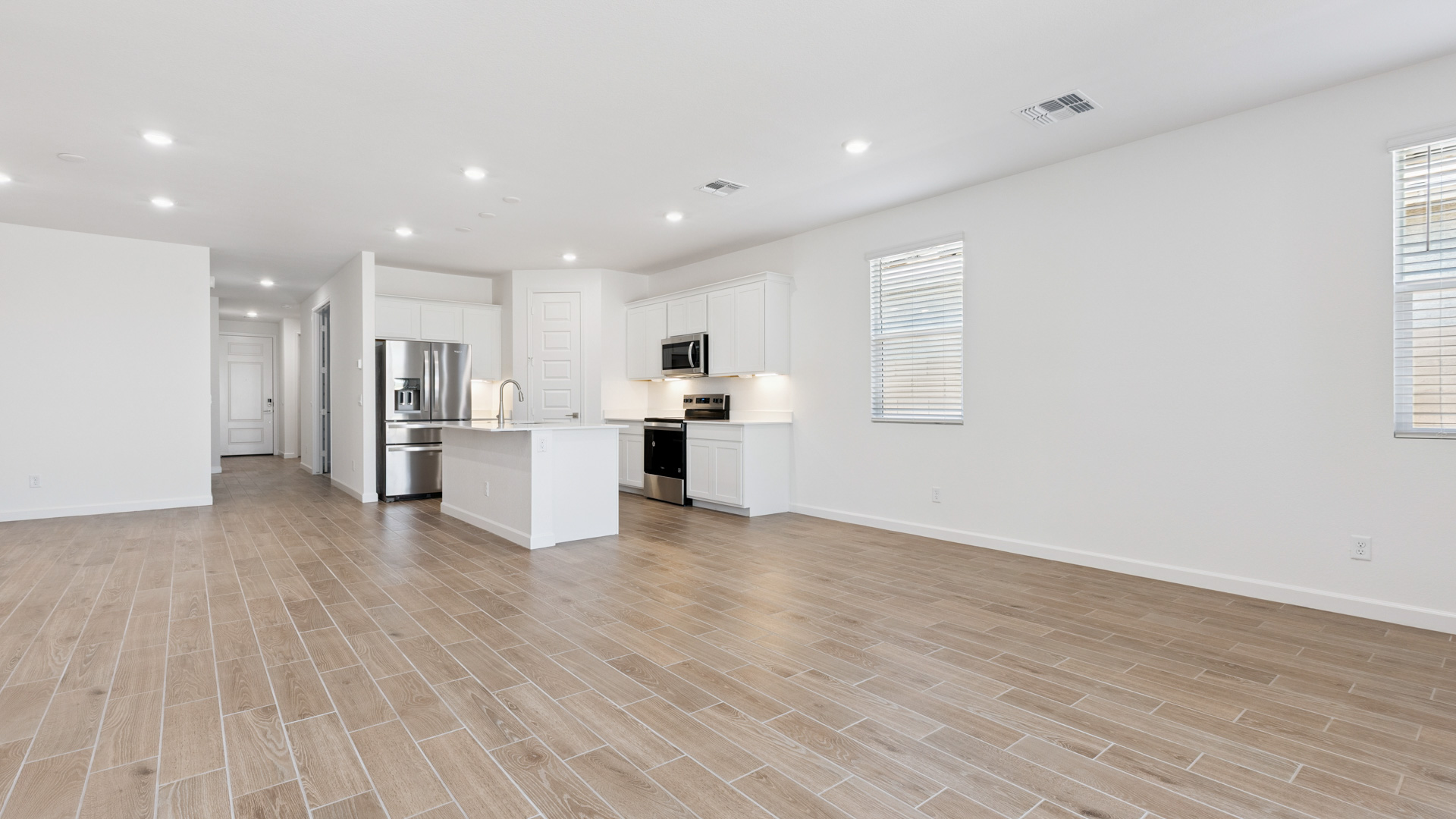 A well-organized living room that includes a kitchen and dining area, creating a warm and welcoming environment for gatherings.