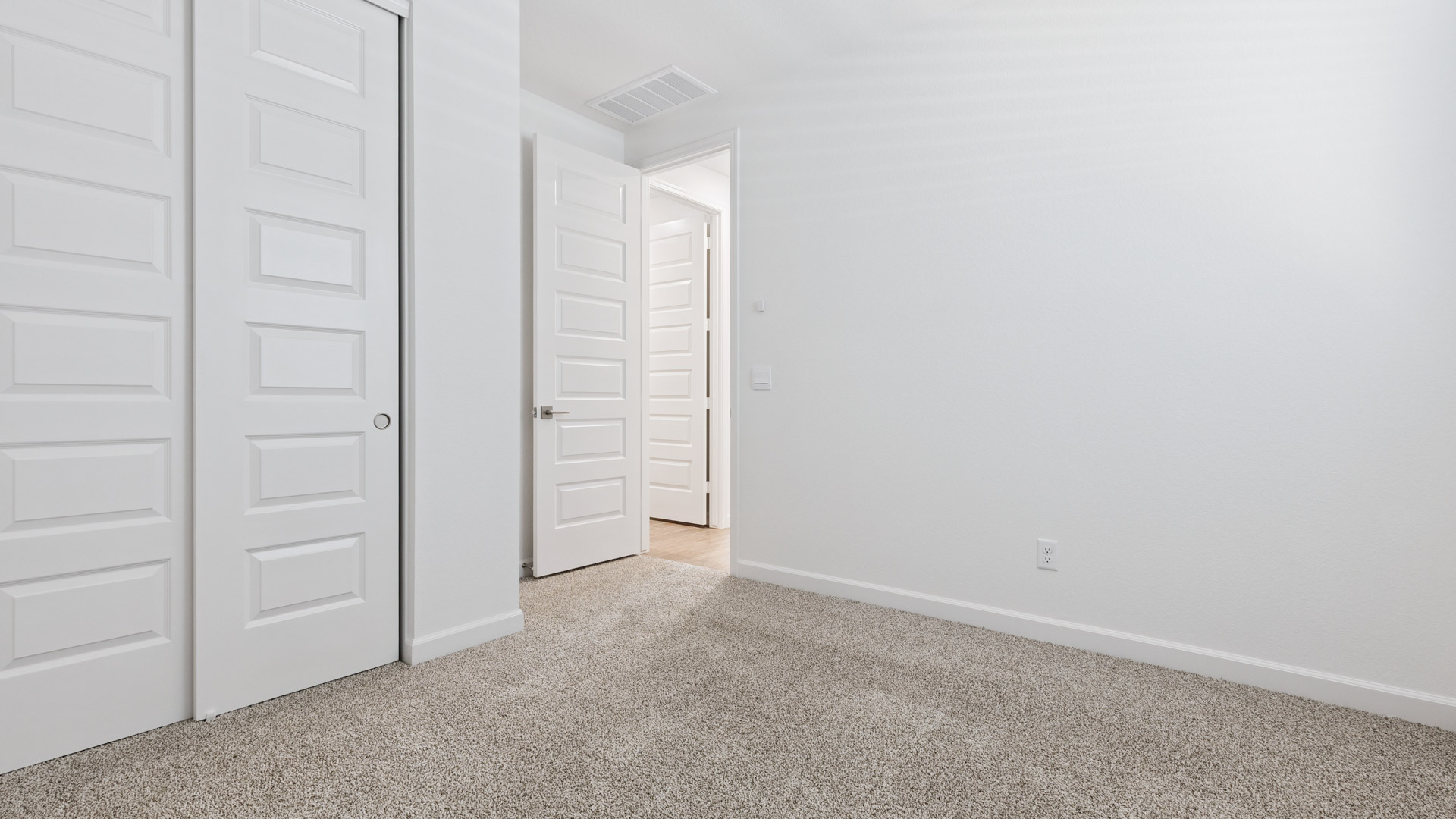 Comfortable guest bedroom featuring neutral-toned walls and a large closet.