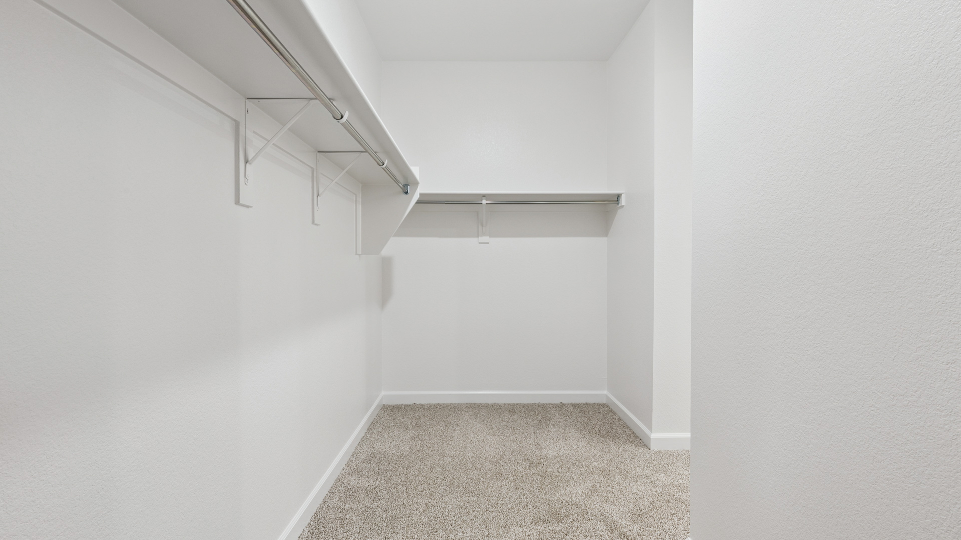 Modern primary bathroom with double vanities, quartz countertops with a walk-in shower and a walk-in closet.