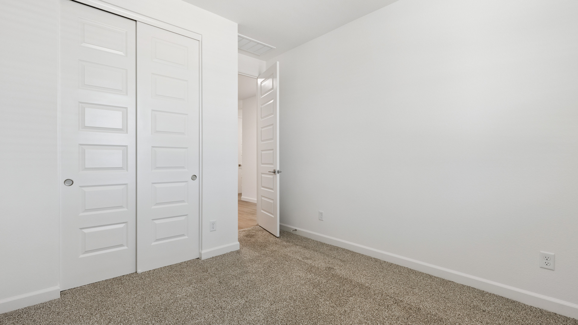 Comfortable guest bedroom featuring neutral-toned walls and a large closet.