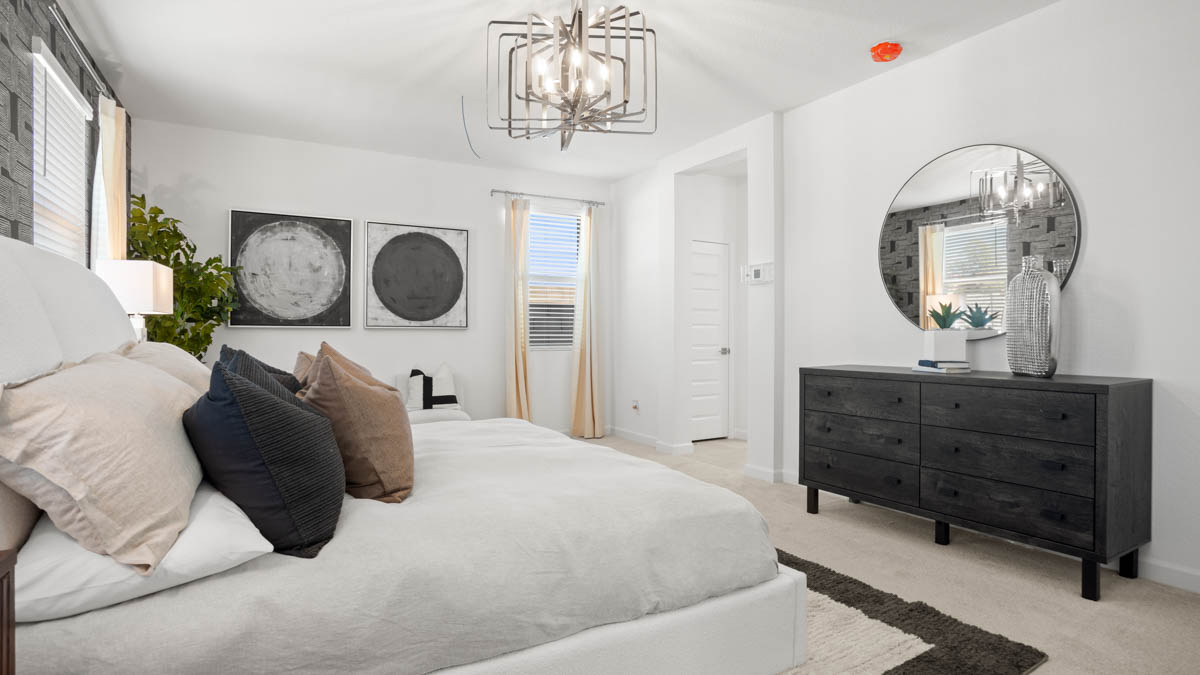 A spacious primary bedroom emphasizing open space and natural lighting.