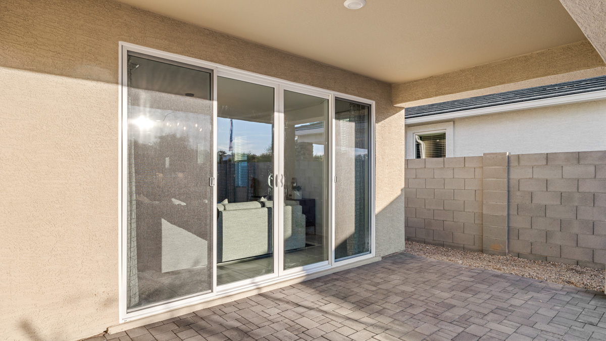 Outdoor covered patio with seating area overlooking a well-maintained lawn, perfect for relaxation.