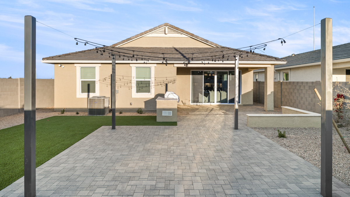 Outdoor covered patio with seating area overlooking a well-maintained lawn, perfect for relaxation.