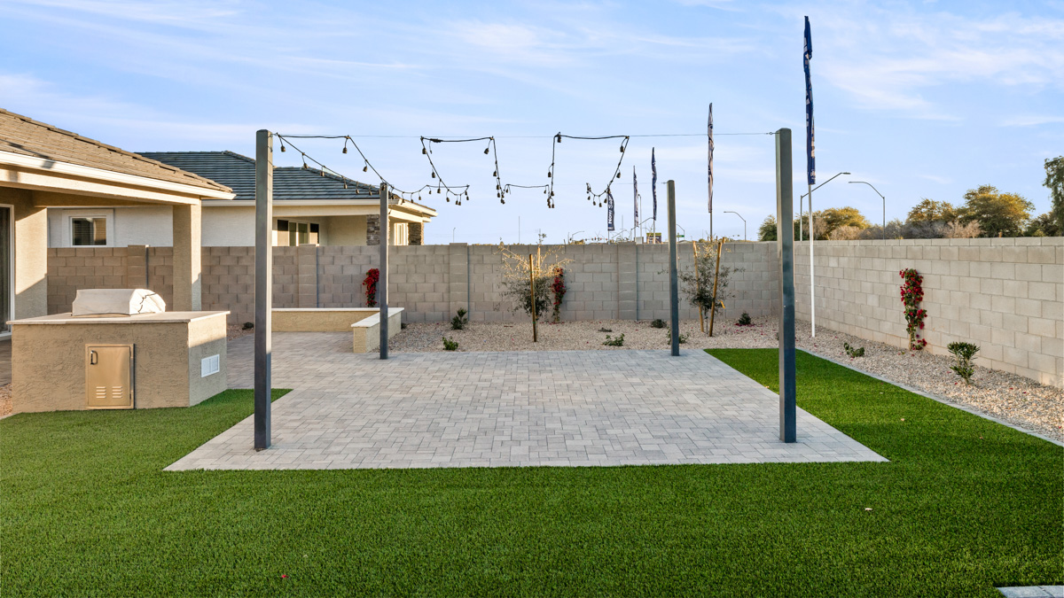 Outdoor covered patio with seating area overlooking a well-maintained lawn, perfect for relaxation.