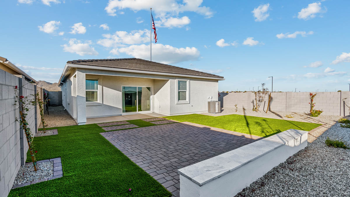 Outdoor covered patio with seating area overlooking a well-maintained lawn, perfect for relaxation.