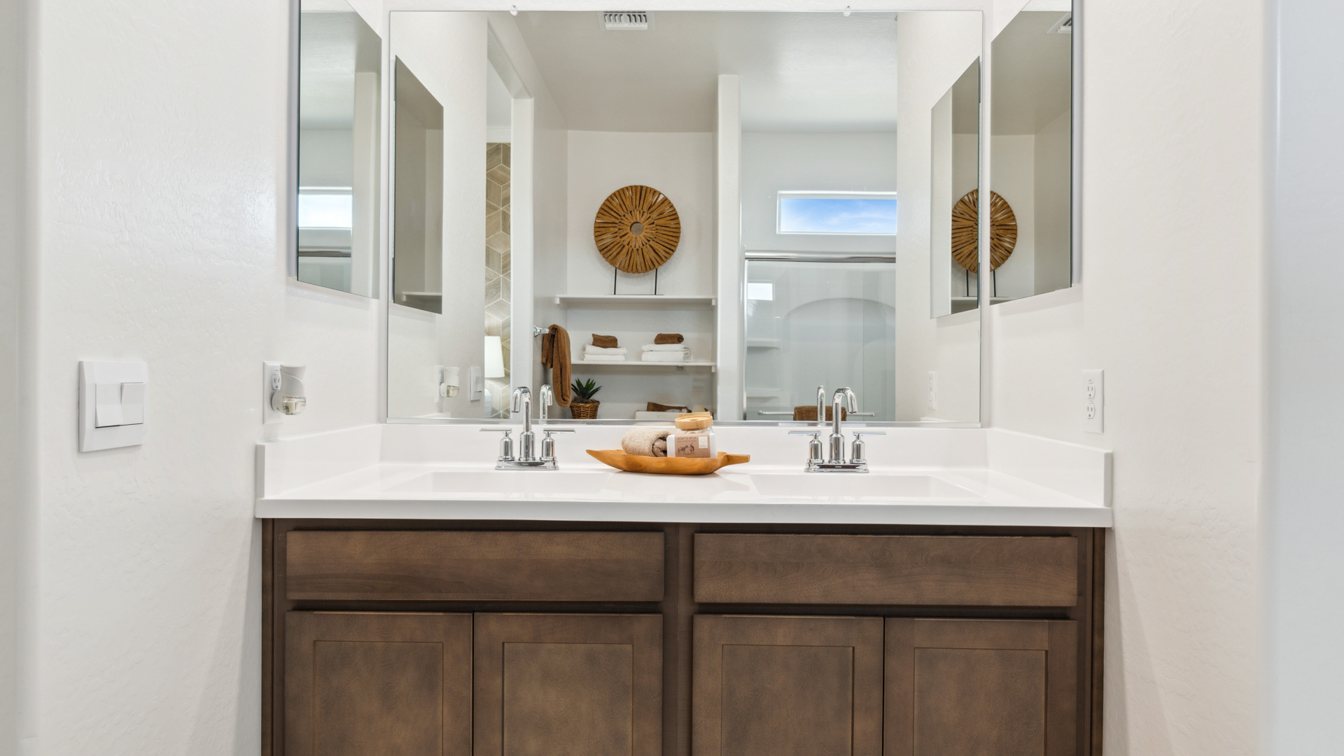 Modern primary bathroom with double vanities, countertops with a walk-in shower and a walk-in closet.