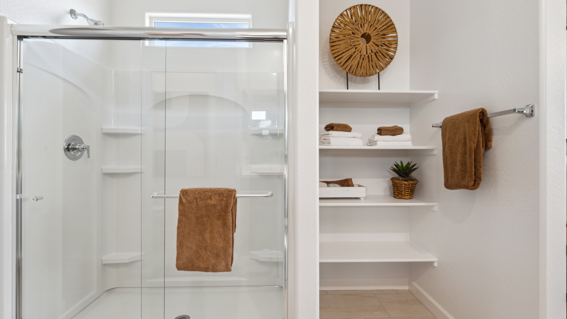 Modern primary bathroom with double vanities, countertops with a walk-in shower and a walk-in closet.