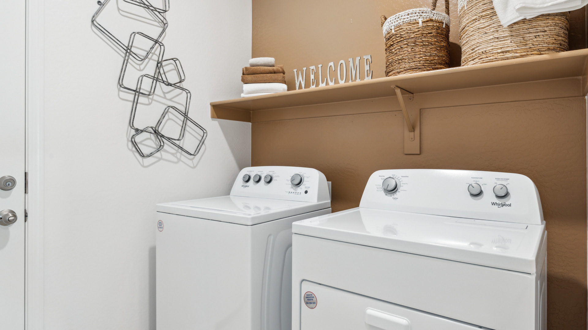 A laundry room featuring a washer and dryer, neatly arranged with ample space for laundry tasks and storage.