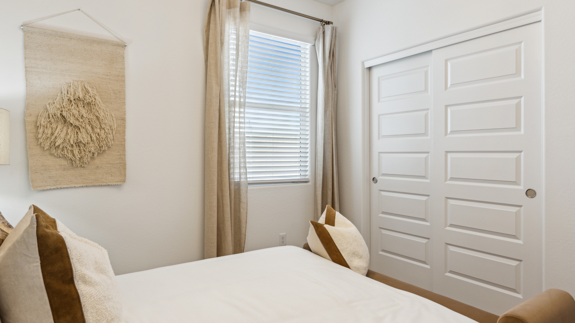 Comfortable guest bedroom featuring neutral-toned walls and a large closet.