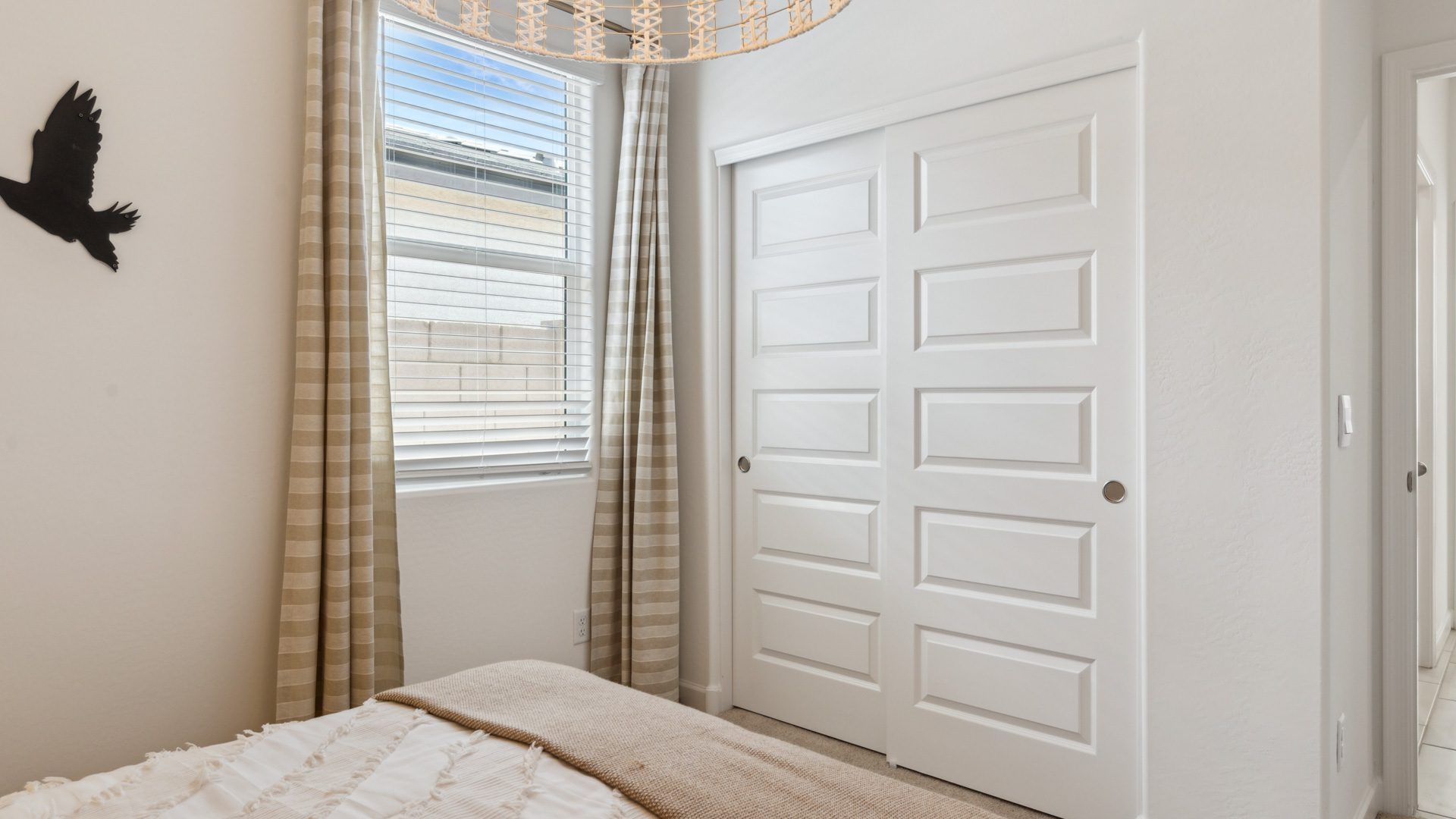 A vibrant kids' bedroom showcasing a neatly made bed, a stylish dresser, and a playful painting that adds charm.