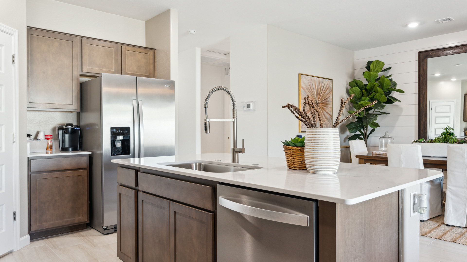 Bright and spacious kitchen with countertops, stainless steel appliances, and an island with bar seating.