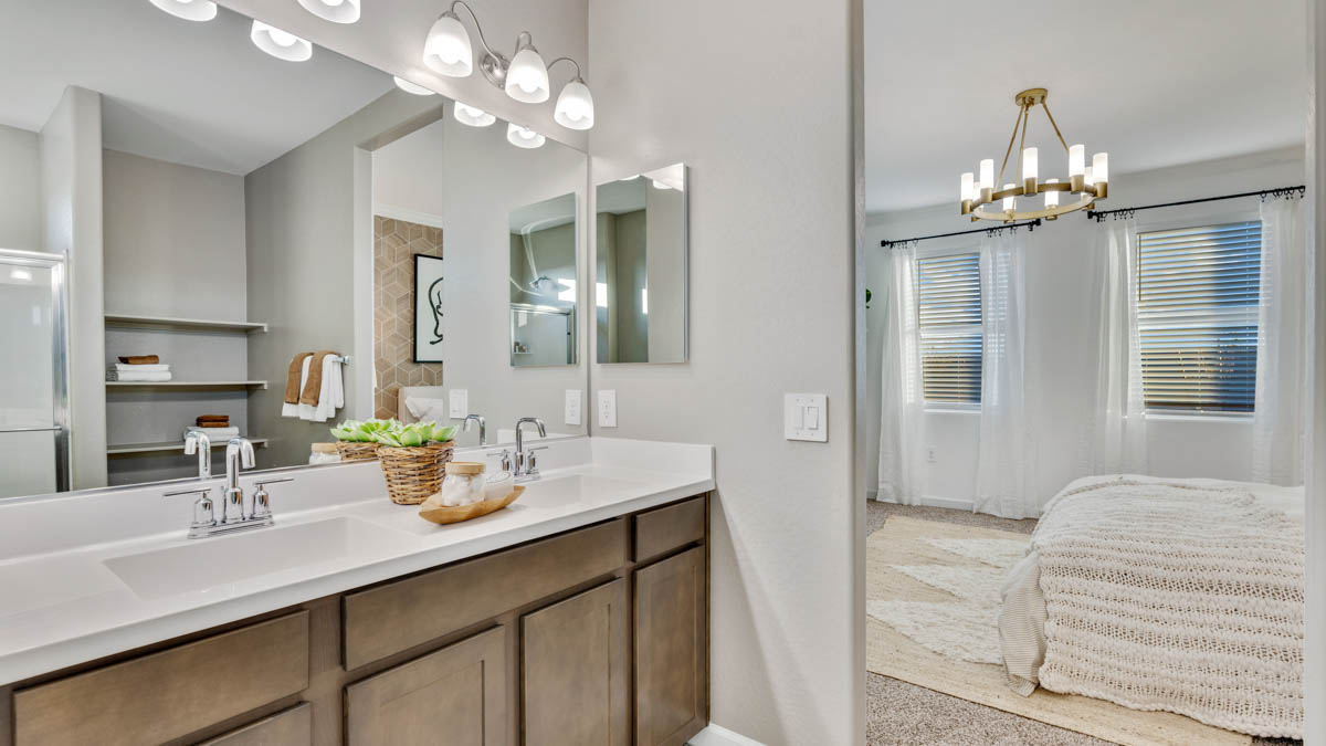 Modern primary bathroom with double vanities, quartz countertops with a walk-in shower and a walk-in closet.