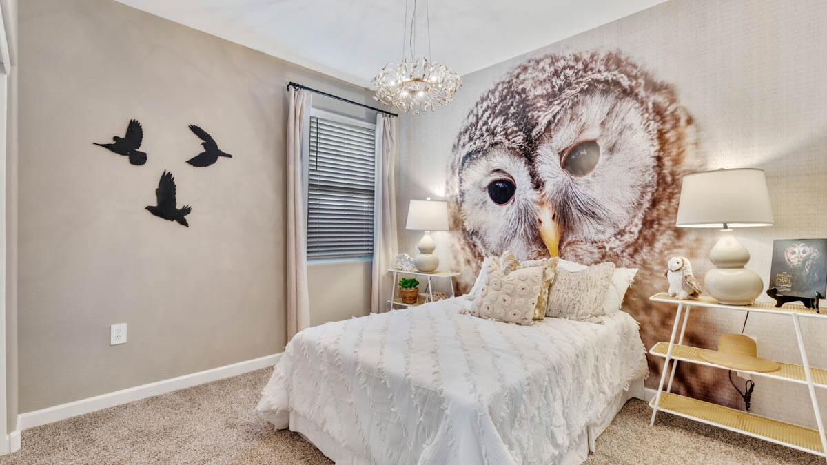A vibrant kids' bedroom showcasing a neatly made bed, a stylish dresser, and a playful painting that adds charm.
