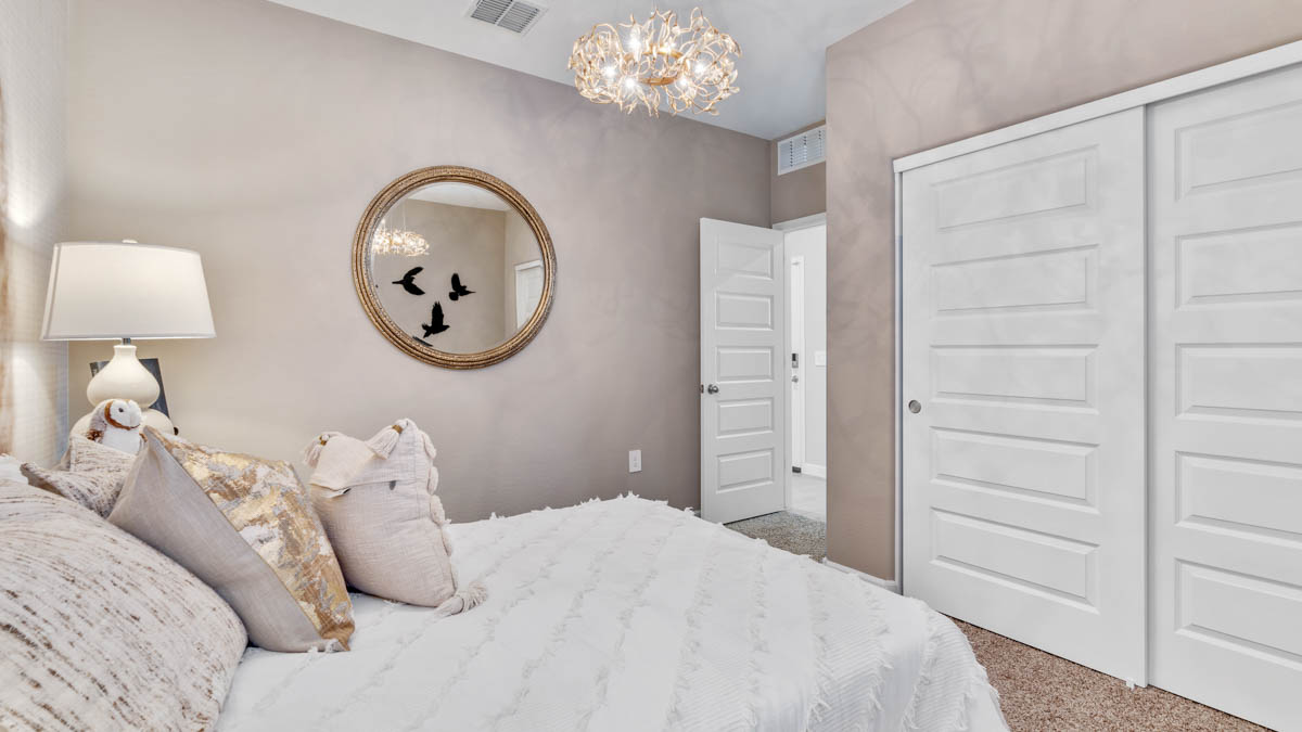 A vibrant kids' bedroom showcasing a neatly made bed, a stylish dresser, and a playful painting that adds charm.